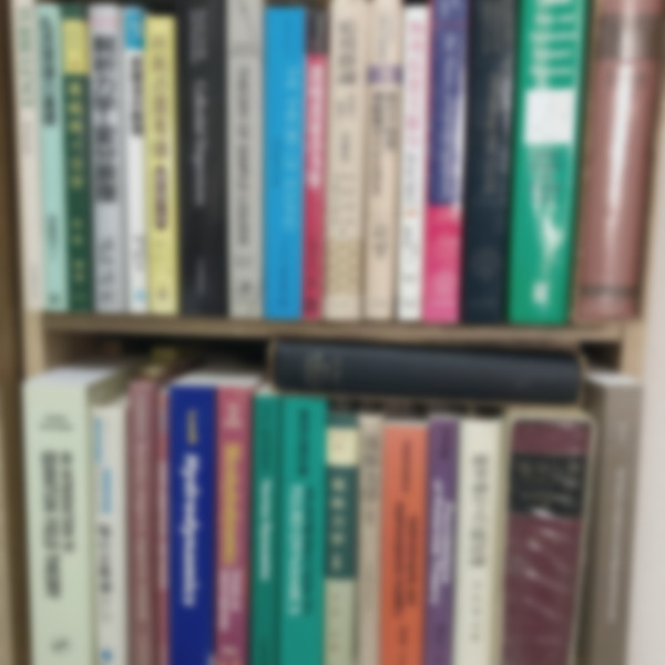 A blurred bookshelf filled with books on fluid mechanics, mathematics, and physics